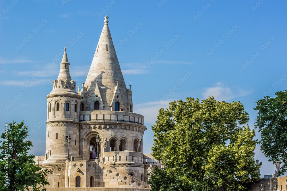 fairy tale white castle palace architecture building with towers on blue sky background between green trees in summer time bright colorful day