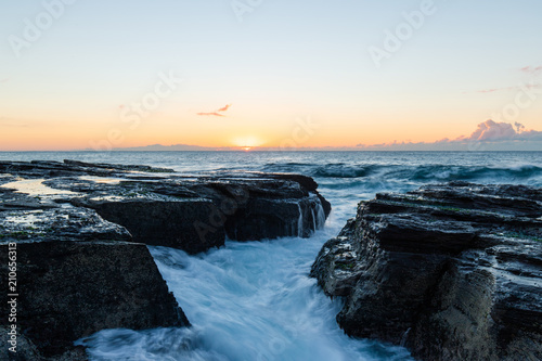 Wave water flowing through between rocks.