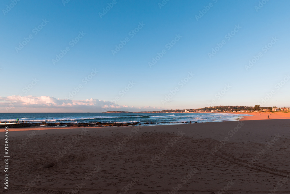 Narrabeen Beach, Sydney in the morning with clear blue sky.