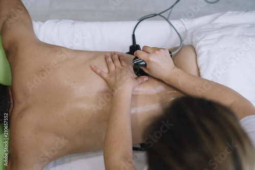 The physiotherapist treating a man using equipment for radio therapy