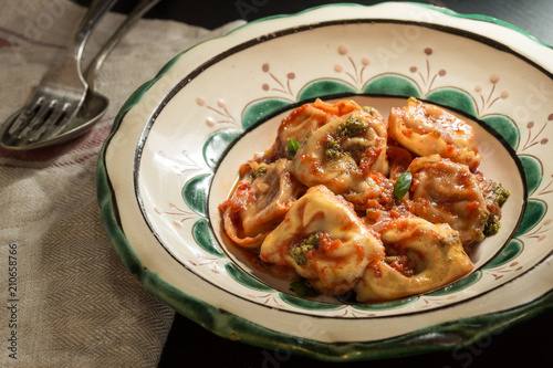 Traditional Italian Tortellini with Tomato Sauce, Mozzarella Cheese and Basil on Rustic Plate