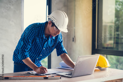 Architect & Engineer working drawing document about project planning and progress of work schedule on the home building construction site