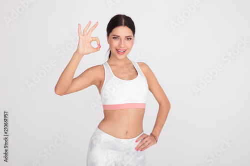 happy fit woman makes perfect fingers sign while standing
