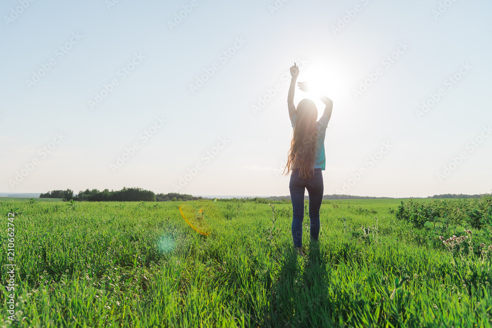 Woman walking in the direction of the sun Woman walking in the direction of the sun