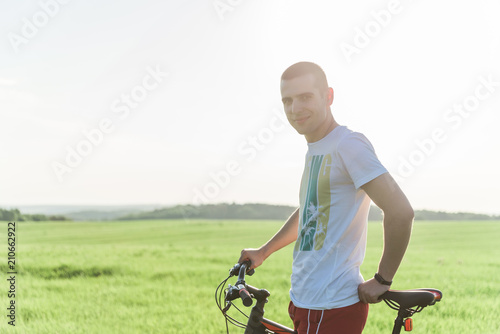 A man standing next to a bicycle