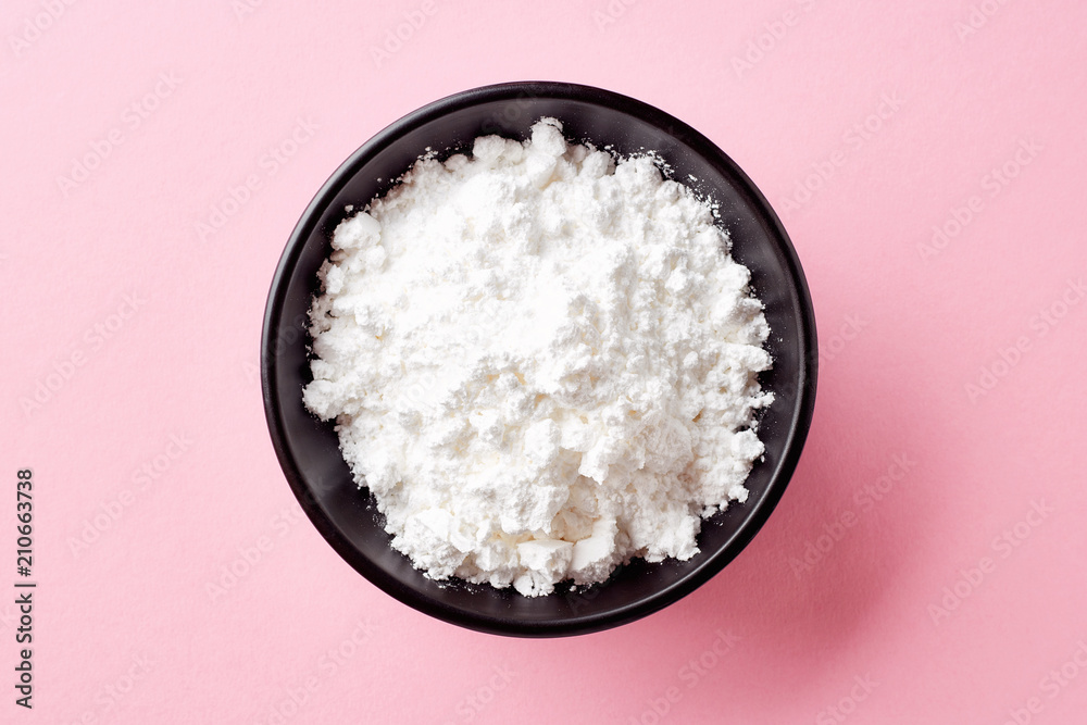 Bowl of powder sugar on white background, from above Bowl of powder sugar on white background, from above