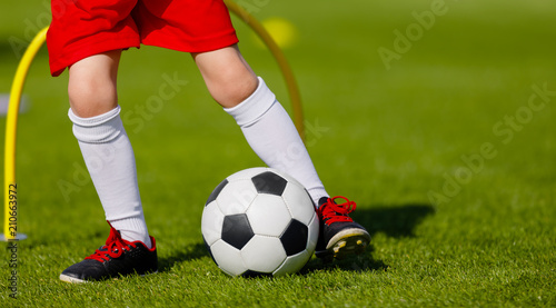 Football Training for Kids. Junior Soccer Training Session Outdoor. Young Boy Kicking Soccer Ball on grass Field