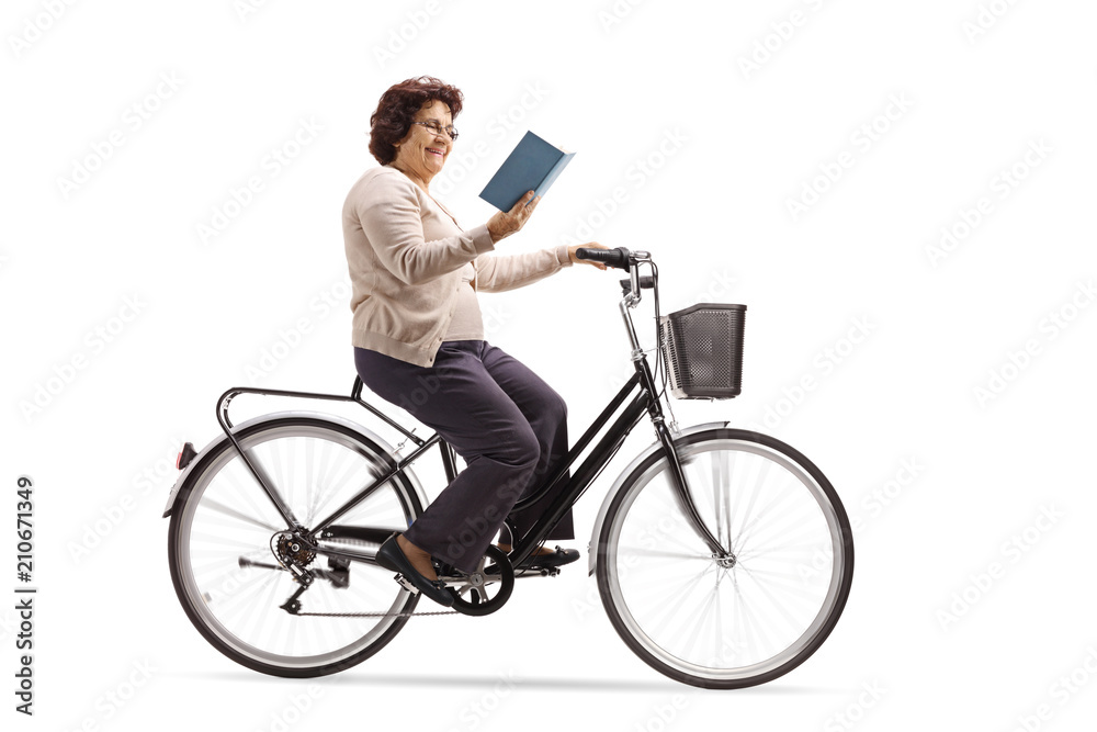 Mature woman riding a bicycle and reading a book Mature woman riding a bicycle and reading a book