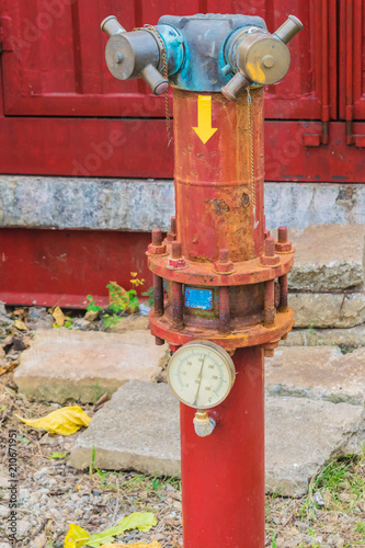Old fire extinguisher for connecting with fire hose in community.