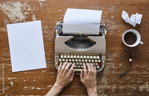 female hands on keyboard writing a novel and drinking coffee