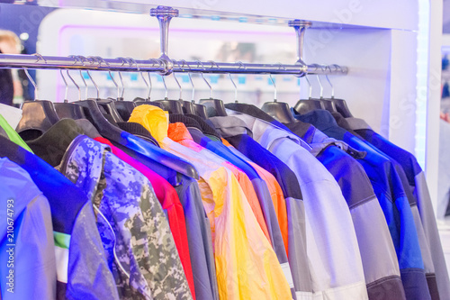 The upper work clothes of strong fabric of different colors with pockets hang on the hangers as a sample
