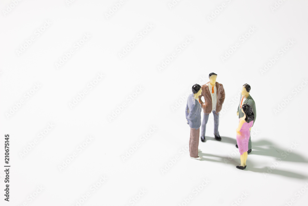 A small group of miniature businessman stand meeting on white background. A small group of miniature businessman stand meeting on white background.