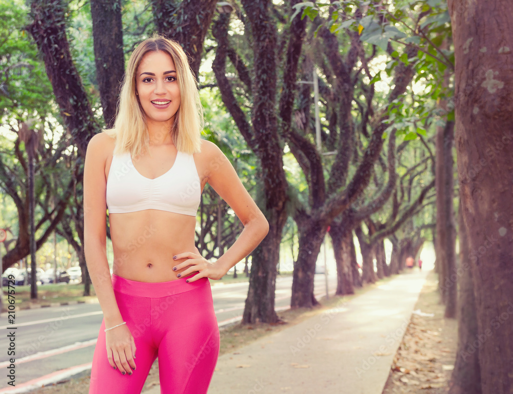 Happy blonde woman smiling and looking at camera. Wooded area. Happy blonde woman smiling and looking at camera. Wooded area.