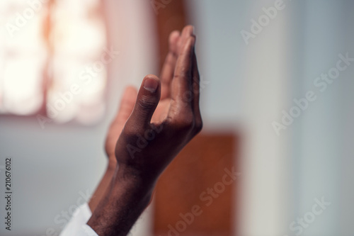 Hand of muslim black man people praying with mosque interior background