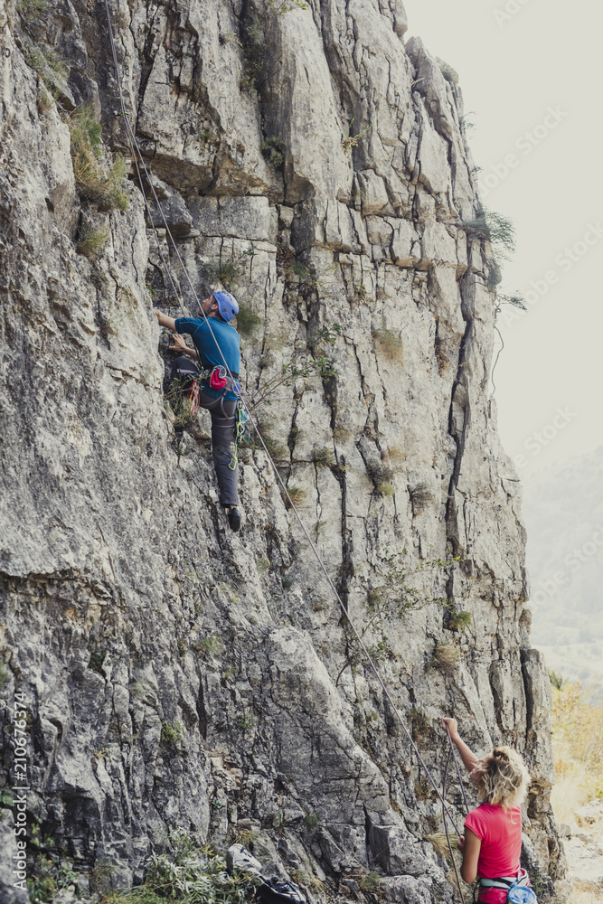 Man and Woman Climbers Climbing a Rock