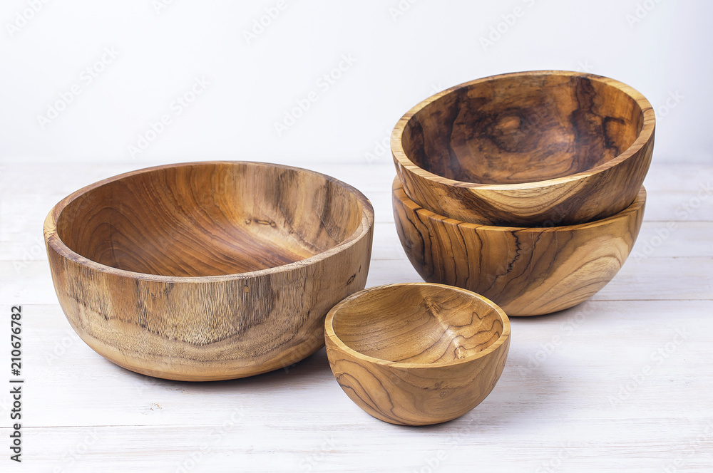 Wooden utensils for the kitchen, bowls, plates on a light background. The concept of natural dishes, a healthy lifestyle. Texture of wood. Wooden utensils for the kitchen, bowls, plates on a light background. The concept of natural dishes, a healthy lifestyle. Texture of wood.