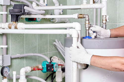 Plumber doing maintenance jobs for water and heating systems photo