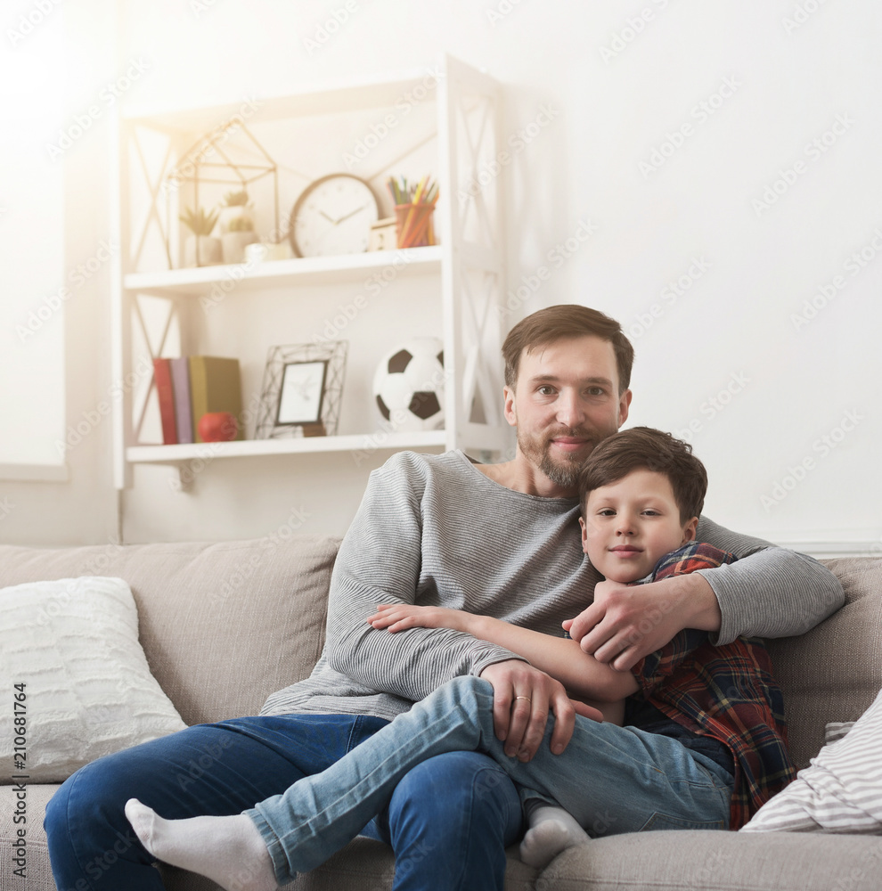 Dad and his son hugging on sofa at home