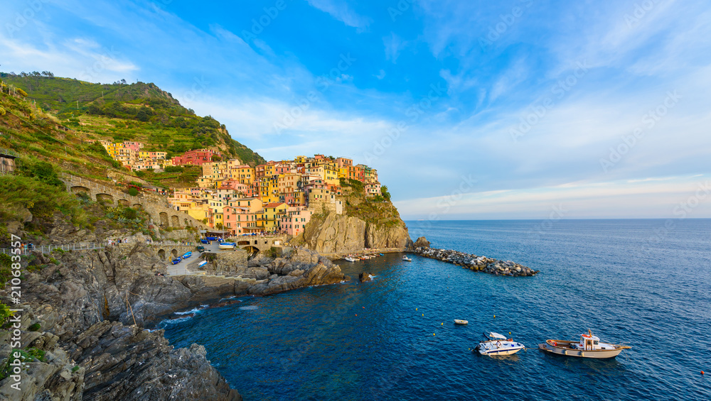 Fototapeta premium Manarola - Village of Cinque Terre National Park at Coast of Italy. Beautiful colors at sunset. Province of La Spezia, Liguria, in the north of Italy - Travel destination and attractions in Europe.