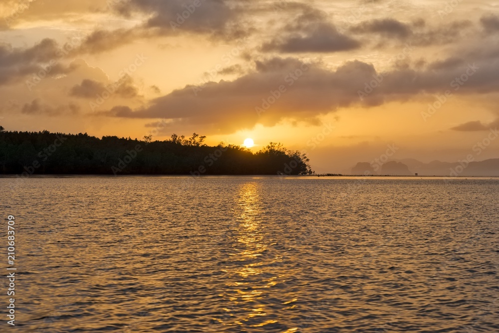 Beautiful sunset with golden sky in Phang Nga Bay, Thailand