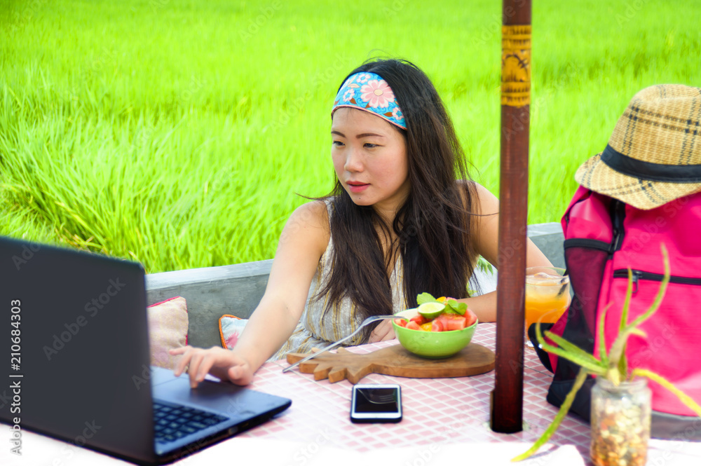young attractive and happy Asian Korean digital nomad working outdoors relaxed with laptop computer at tropical cafe in success online job young attractive and happy Asian Korean digital nomad working outdoors relaxed with laptop computer at tropical cafe in success online job