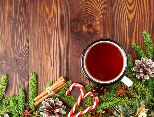 Christmas and Happy New Year background with tea. Top view, copy space. Fir branches, brown dark wooden table