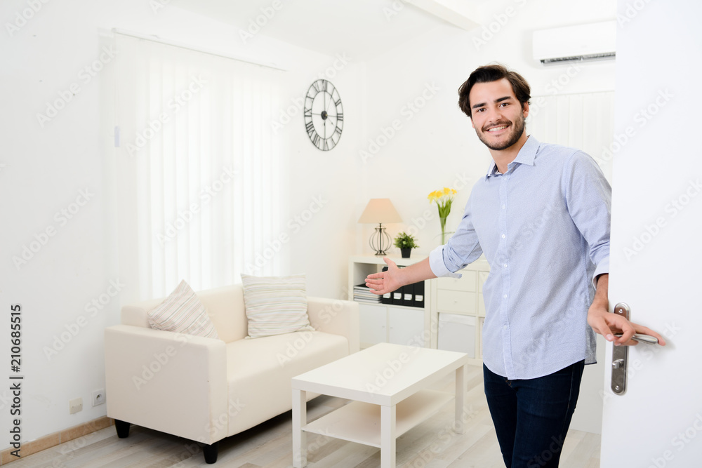 handsome young man welcome friends at open front door new student home apartment handsome young man welcome friends at open front door new student home apartment