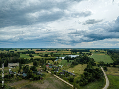 drone image. aerial view of rural area with houses and roads under heavy rain clouds