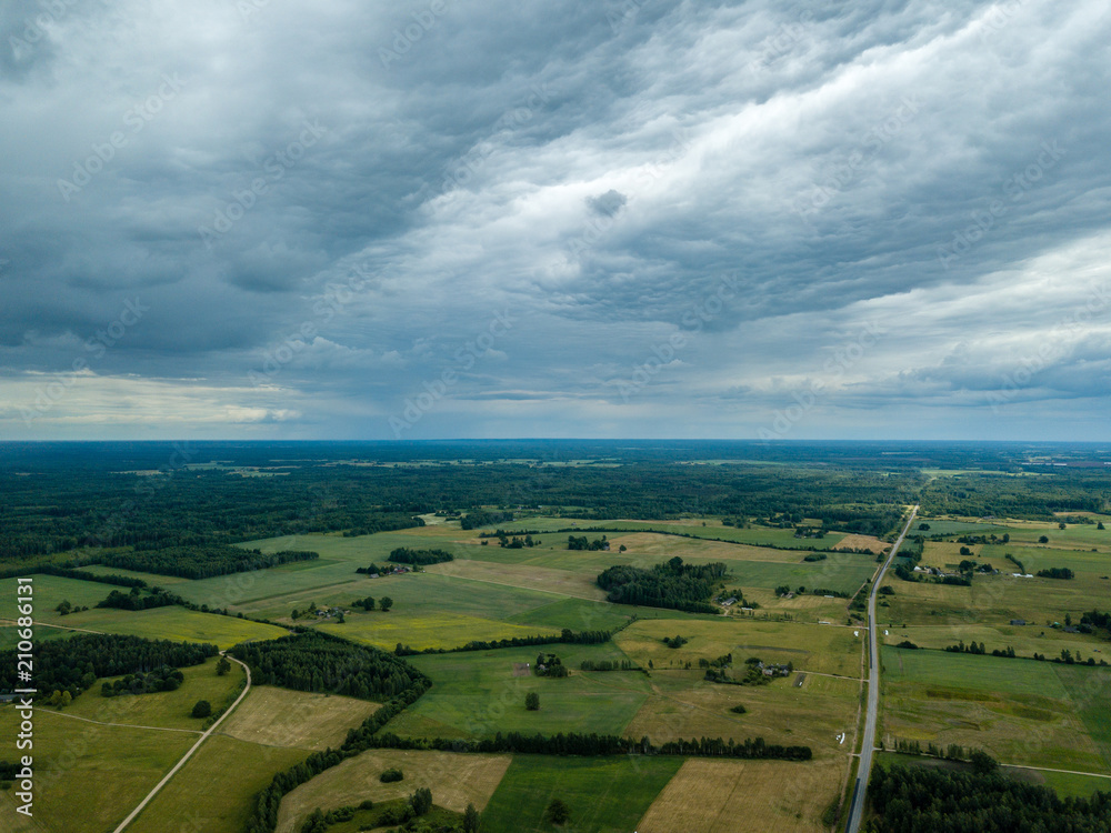 drone image. aerial view of rural area with houses and roads under heavy rain clouds