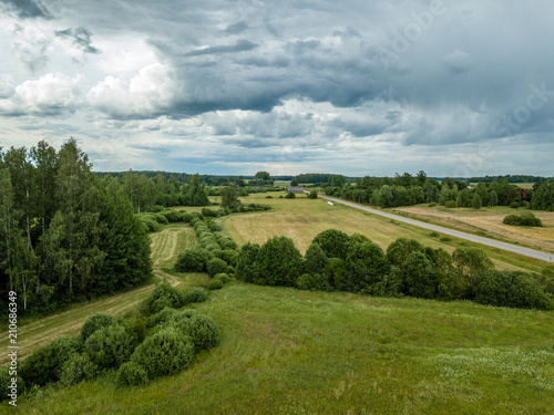 drone image. aerial view of rural area with houses and roads under heavy rain clouds