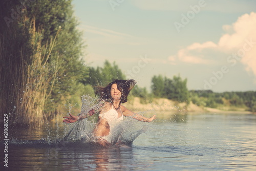 Fototapeta Naklejka Na Ścianę i Meble -  Tattooed Woman Jumping into Water