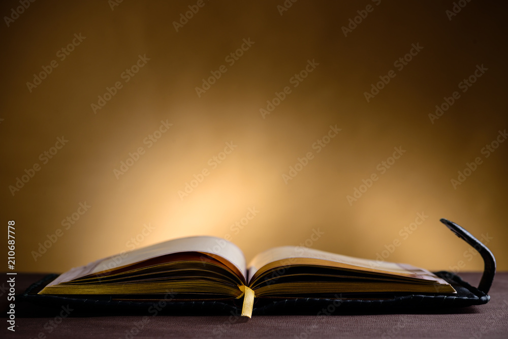 Still life with open old book on the wooden table Still life with open old book on the wooden table