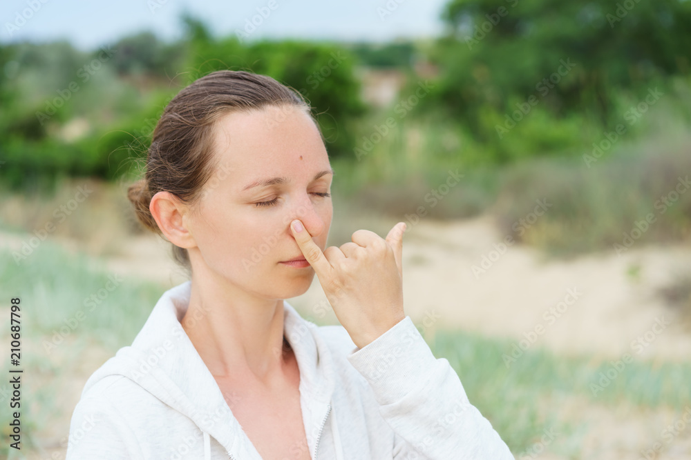 Young girl performs morning breathing practices of pranayama Nadi Shodhana on the beach in summer Young girl performs morning breathing practices of pranayama Nadi Shodhana on the beach in summer