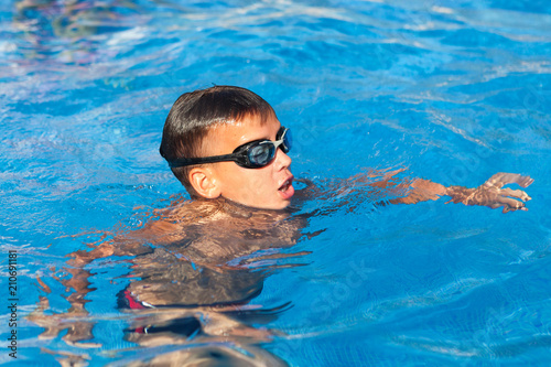 boy is swimming in pool, outdoor