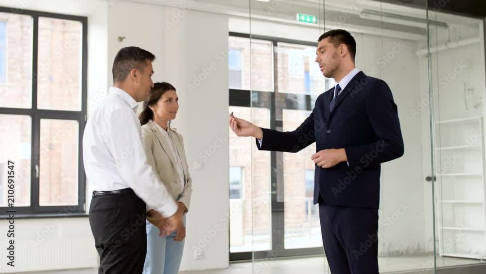 real estate business, sale and people concept - realtor giving key to customers or new office owners real estate business, sale and people concept - realtor giving key to customers or new office owners