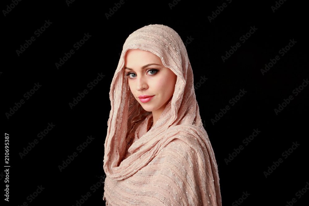 portrait of pretty girl wearing a pink headscarf. black studio background. portrait of pretty girl wearing a pink headscarf. black studio background.