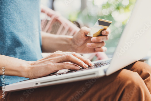 Young woman holding credit card and using laptop computer, Travel and online shopping concept