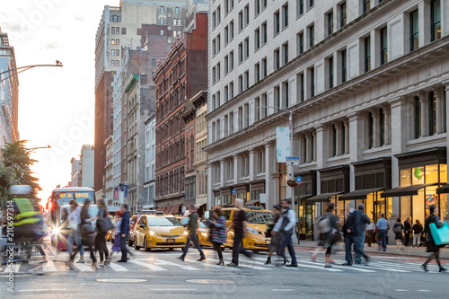 Fotografia, Obraz Fast paced street scene with people walking across a busy intersection on Broadw