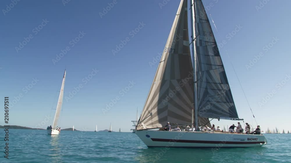 A slow motion shot of sailboats sailing the blue ocean. The shot is taken during the summertime. A slow motion shot of sailboats sailing the blue ocean. The shot is taken during the summertime.