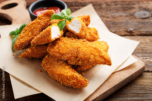 Fototapete Delicious crispy fried breaded chicken breast strips with ketchup