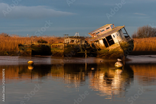 Morning sun on wrecked barges on river bank, Topsham, England  photo