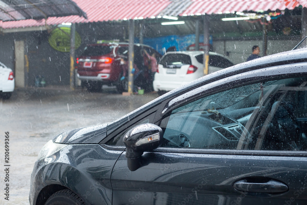 Rain dropping on deep blue car after car wash done.
