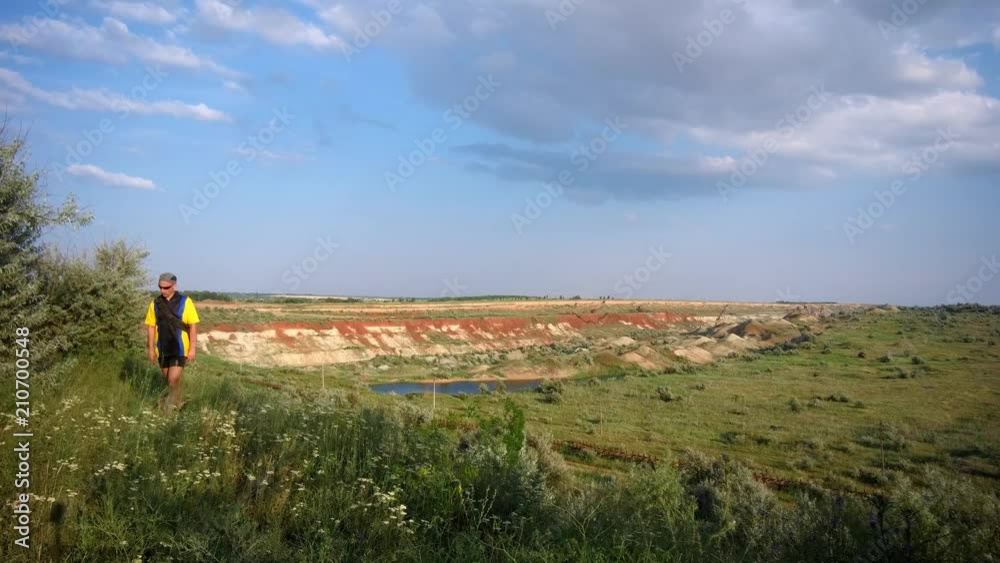 A male tourist travels along an old quarry for manganese mining