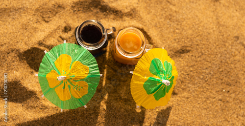 colorful shots drinks on a sandy beach with umbrellas for drinks