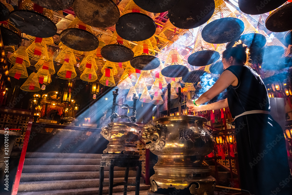 Fototapeta premium Sheung Wan, Hong Kong - May 29, 2018 : Woman praying in misty temple