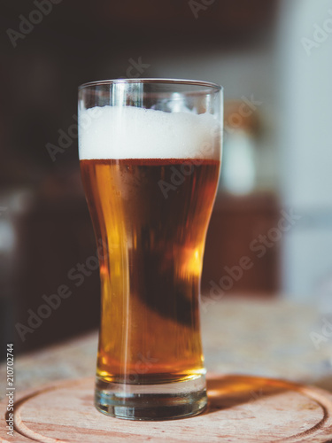 Glass of cold light beer on the kitchen table