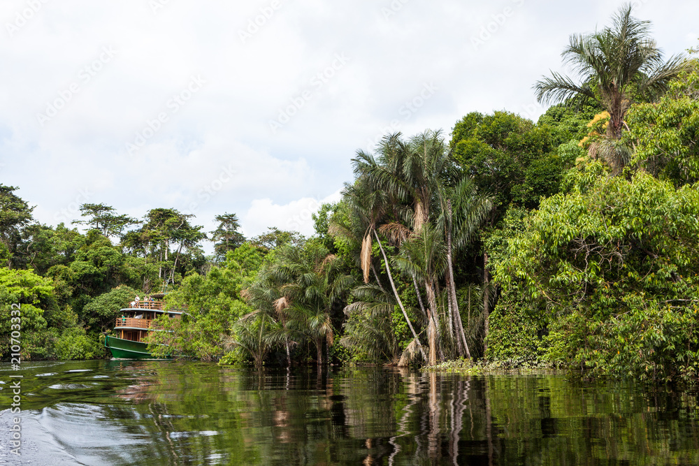 Amazonas, Brazil. A traditional wooden boat on an affluent river of the Negro River in the Amazon. Amazonas, Brazil. A traditional wooden boat on an affluent river of the Negro River in the Amazon.
