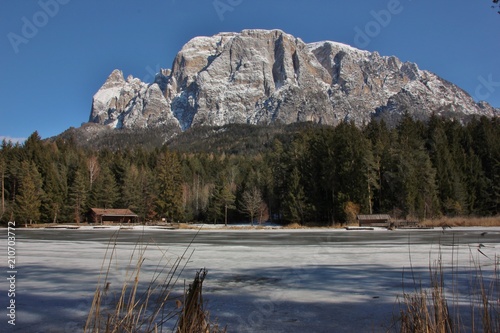 Iced Lago di Fié, view on Monte Sciliar, South Tyrol, Dolomites, Italy