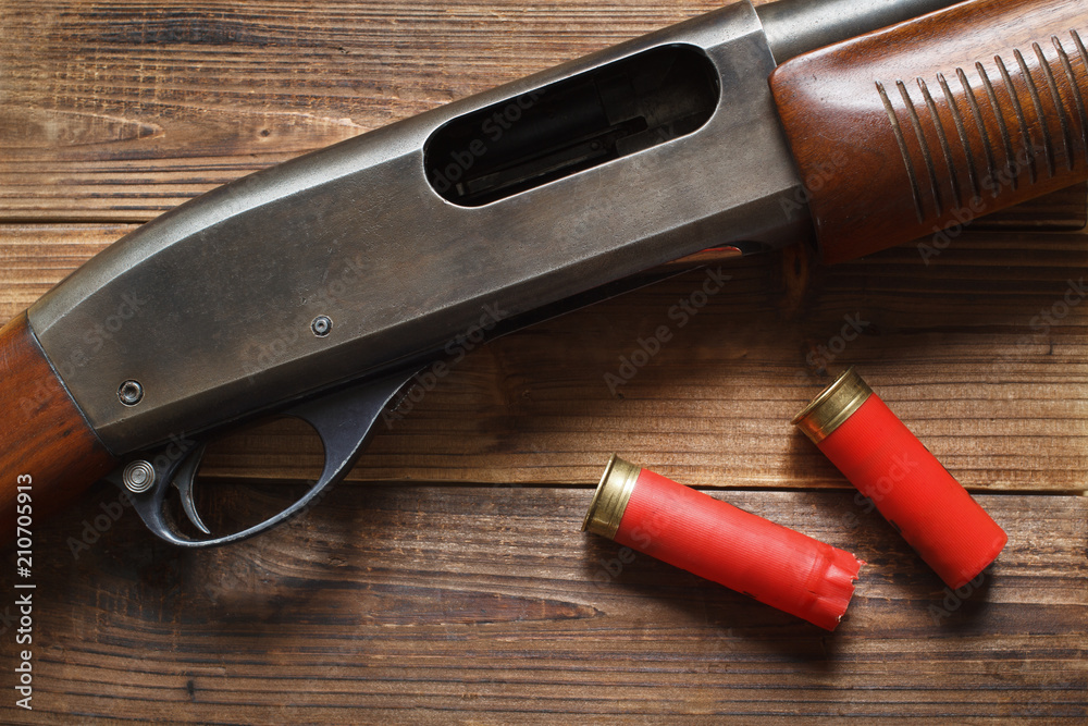 12 gauge pump action shotgun on wood detail and shells. 12 gauge pump action shotgun on wood detail and shells.