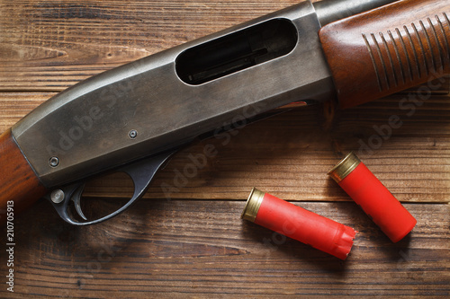 12 gauge pump action shotgun on wood detail and shells.